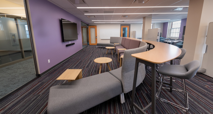 A view of the wall-mounted LCD Screen curved table and seating accommodations in the innovation hub