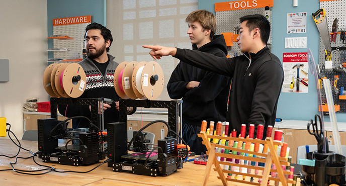 Students examining equipment in the Fab Lab